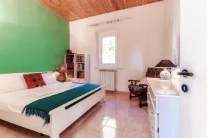 a bedroom with a white bed and a green wall at Varenna Wonders by Quokka 360 - Lakeside villa with breathtaking view in Fiumelatte
