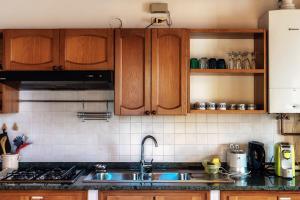 a kitchen with wooden cabinets and a sink at Varenna Wonders by Quokka 360 - Lakeside villa with breathtaking view in Fiumelatte