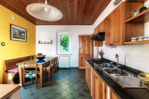 a kitchen with a sink and a table with chairs at Varenna Wonders by Quokka 360 - Lakeside villa with breathtaking view in Fiumelatte