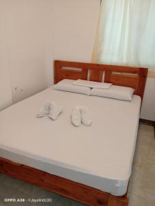 a bedroom with a bed with two slippers on it at Lapyahan Guest House Room 5 in Lalao