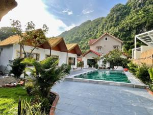 a house with a swimming pool in front of a mountain at Tam Coc Harmony Homestay in Vũ Lâm