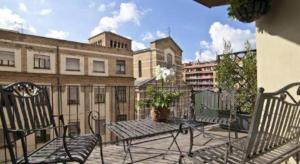 a balcony with two benches and a table and buildings at Marroad Inn Tokyo in Chofu