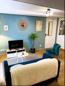 a living room with a couch and a tv at Le Dolce Vita Cœur de ville in Dole