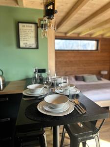 a black table with plates and glasses on it at Lodge with private spa in Geishouse