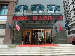 two people standing in front of a building at GreenTree Inn LangFang YanJiao Tianyang Plaza Express Hotel in Gaolou