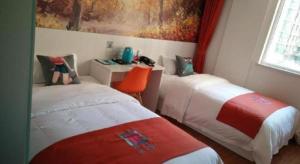 a bedroom with two beds and a painting on the wall at Pai Hotel Yanjiao Tianyang Plaza in Gaolou +1 photo