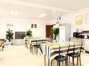 a restaurant with tables and chairs and a kitchen at GreenTree Inn Nanjing Lishui District Lishui Airport Road Express Hotel in Lishui