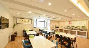 a dining room with tables and chairs in a restaurant at GreenTree Inn Huainan Shou County Zijin Road Express Hotel in Majiaxu