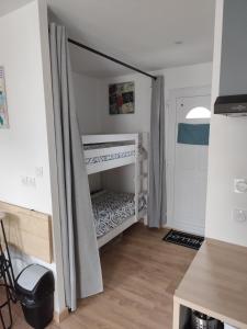a small bedroom with a bunk bed with curtains at Charmant studio indépendant en RDC chez Cyril et Stéph in Millas