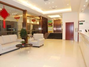 a lobby with two white couches and a table at GreenTree Alliance Yichang East Yichang Station Hotel in Yichang