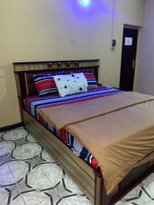 Un dormitorio con una cama con marco de madera. en AY Hotel Reloaded, en Ikeja