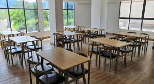 a classroom with wooden tables and chairs and windows at GreenTree Inn Xianning Tongshan Yangdu Avenue in Xianning