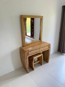 a wooden bench with a mirror on a wall at AMED LILI Private Room in Amed