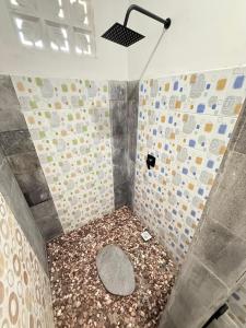 a bathroom with a shower with a pebble floor at AMED LILI Private Room in Amed +9 photos