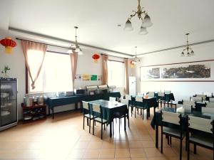 a restaurant with tables and chairs in a room at GreenTree Inn Dongying Xisi Road Huachuang Building in Dongying