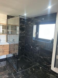 a bathroom with a glass shower and a sink at Hébergement curgy in Curgy