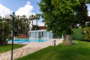 アンドリアにあるB&B Villa Adrianaのプールと木のある家