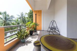 パンタイチェナンにあるHotel O Big C Motelの木製テーブルと植物のあるバルコニー