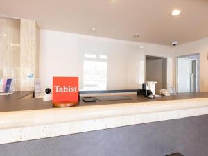 a kitchen with a counter with a sign on it at Tabist Hotel New Osamura Sabae in Fukui +98 photos
