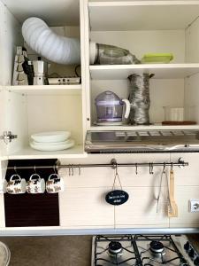 un armario con vajilla y otros utensilios de cocina en Bright and cozy apartment in the city center with balcony, en Šiauliai