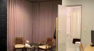 Una habitación con dos sillas y una mesa con televisión. en Fuji Shoei kaikan, en Fuji