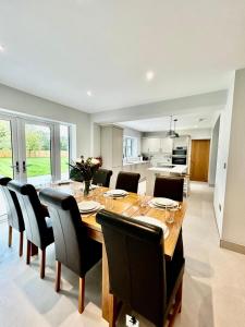 a kitchen and dining room with a wooden table and chairs at Marzion House with Hot Tub in Tattershall Thorpe