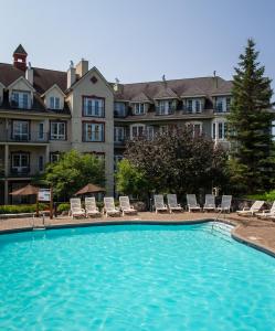 a large swimming pool in front of a large building at Tour des Voyageurs in Mont-Tremblant