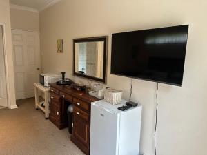 TV en la pared de una cocina con nevera en Clivia Guesthouse, en Pietermaritzburg
