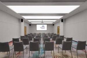 a room with a bunch of chairs and a screen at Hangzhou Qiantang Shama Hotel in Hangzhou