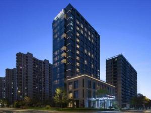 a tall building in front of two tall buildings at Hangzhou Qiantang Shama Hotel in Hangzhou