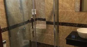 a glass shower door in a bathroom with a sink at Phuong Ly Ly in Ho Chi Minh City