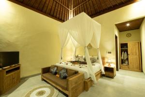 una camera da letto con un letto a baldacchino di Rama Ubud Villa ad Ubud Altre 37 foto