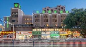 a building with green lights on top of it at GreenTree Inn Geermu Walking Street Business Hotel in Golmud