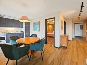 a kitchen and dining room with a wooden table and chairs at Hotel Aeschi Interlaken - Handwritten Collection in Aeschi