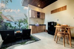 una cucina con tavolo e frigorifero di Rama Ubud Villa ad Ubud