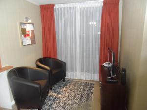 a hotel room with a chair and a window at Departamentos Rohe in Puerto Montt