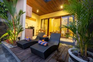 un patio con due sedie nere e cuscini di Rama Ubud Villa ad Ubud