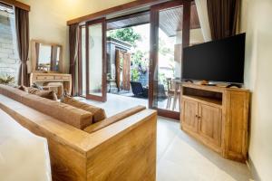un soggiorno con divano e TV a schermo piatto di Rama Ubud Villa ad Ubud