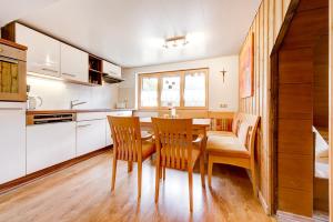 a kitchen with a dining room table and chairs at Ferienhaus Schwendehof in Fontanella
