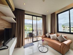 una sala de estar con un sofá y una mesa en Cozy 2 Bedrooms - The Lago Nai Harn by AHP, en Rawai Beach