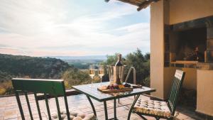 a table and chairs on a patio with a view at Hitgeheim Garden Cottages in Addo +13 photos