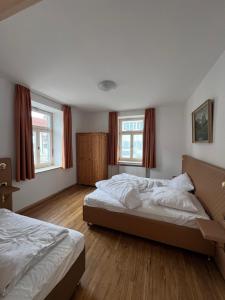 a bedroom with two beds and two windows at Bergblick Apartment 4 in Garmisch-Partenkirchen