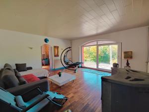 Una sala de estar con un sofá y una ventana grande. en Mountain Getaway - Nordic Hot Tub, Warmth & Nature, en Bussang
