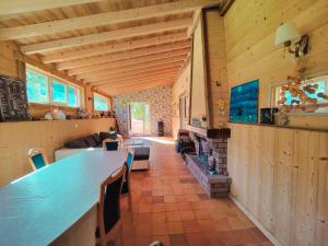 sala de estar con mesa larga y chimenea en Mountain Getaway - Nordic Hot Tub, Warmth & Nature, en Bussang