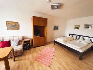 Un dormitorio con una cama, un sofá y una mesa. en Gasthof Söll,  2 fotos más
