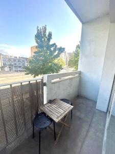 a bench and a chair on a balcony at Bel appartement proche de toutes commodités in Grenoble