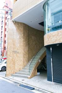 ein Gebäude mit einer Treppe vor einem Gebäude in der Unterkunft Hotel Small World in Hiroshima