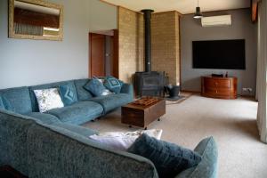 a living room with blue couches and a fireplace at Willow Lodge Retreat in Paringa