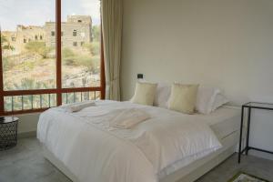 a white bed in a room with a window at Misfah Allure in Misfāh +52 photos