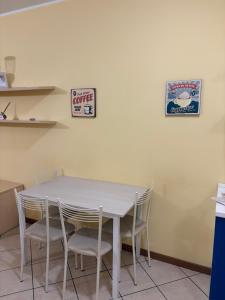 a white table with chairs and a sign on a wall at Apartament Orio 3 in Orio al Serio